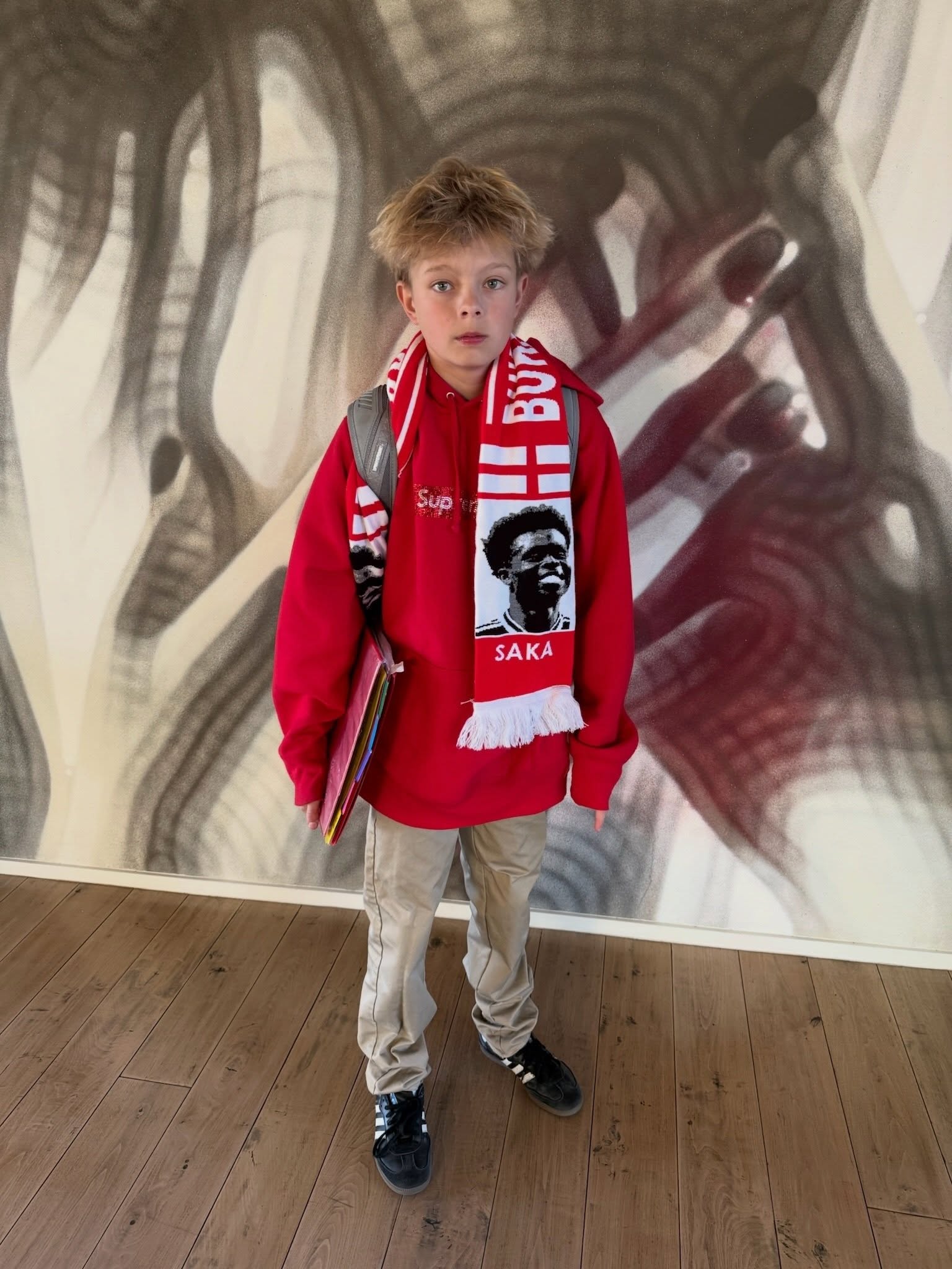 Axl Duhamel in a red hoodie and Saka scarf for his 13th birthday.