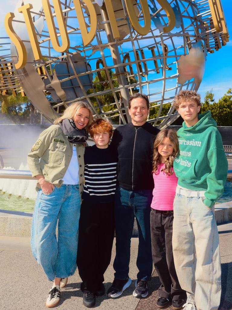 Family of five posing in front of the Universal Studios globe.