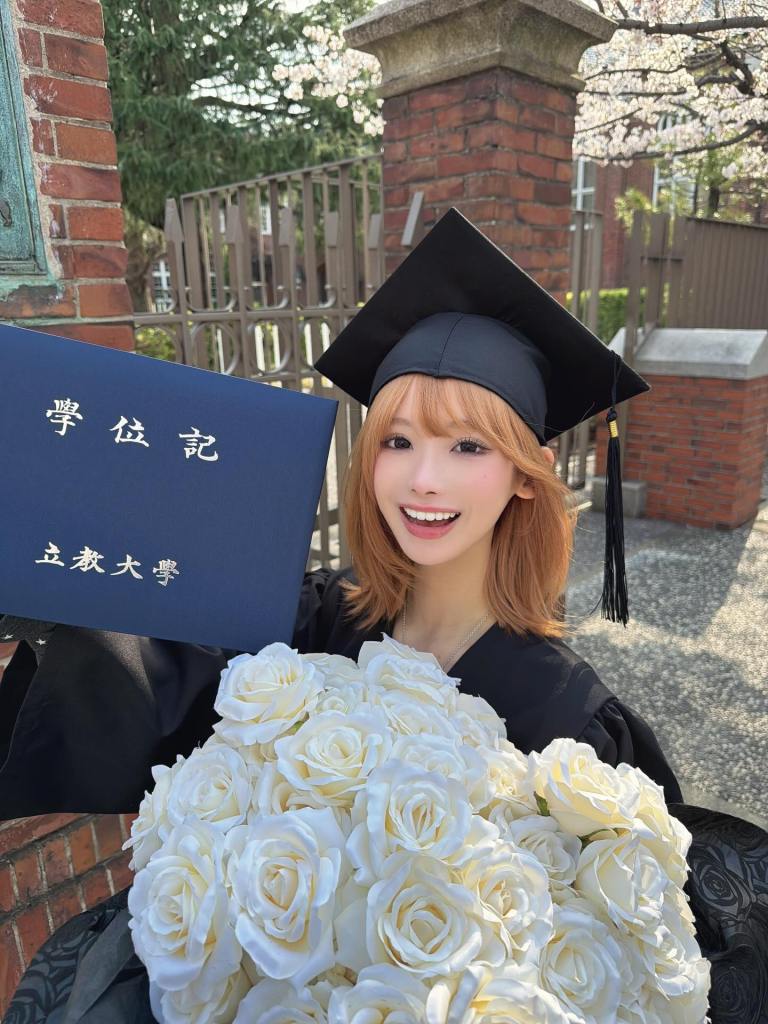 K-pop influencer Mina Chan celebrating graduation in a cap and gown, holding a diploma and a bouquet of white roses.