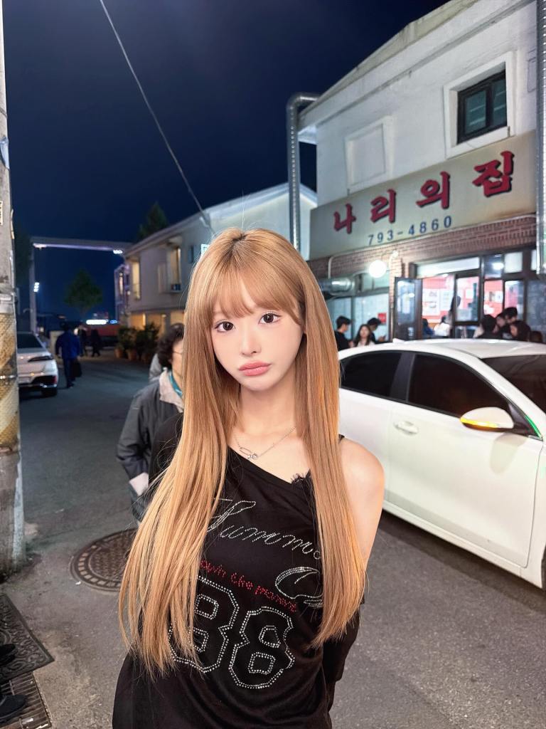 K-pop influencer Mina Chan posing on a street at night.