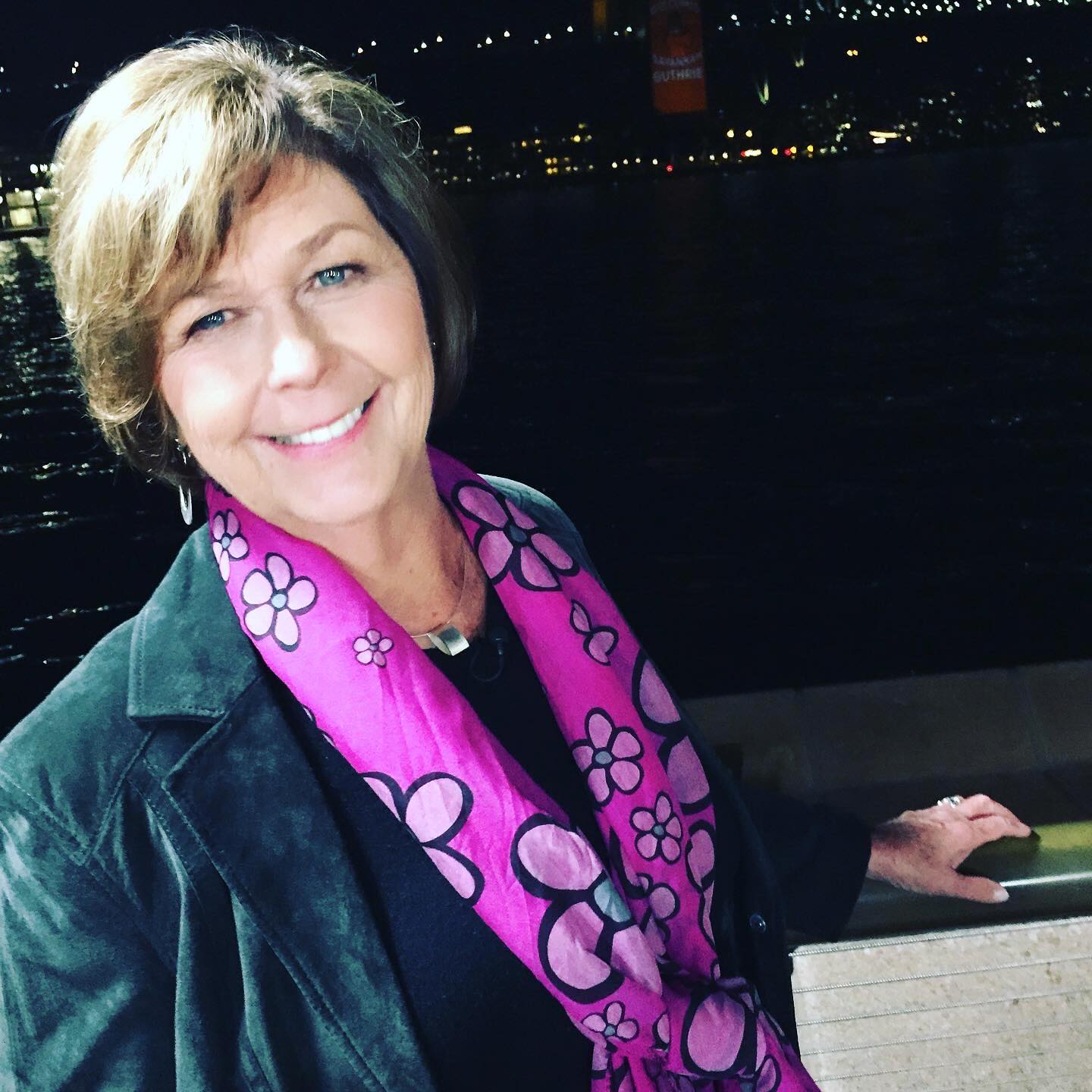 Nancy Guthrie smiling with a pink floral scarf.