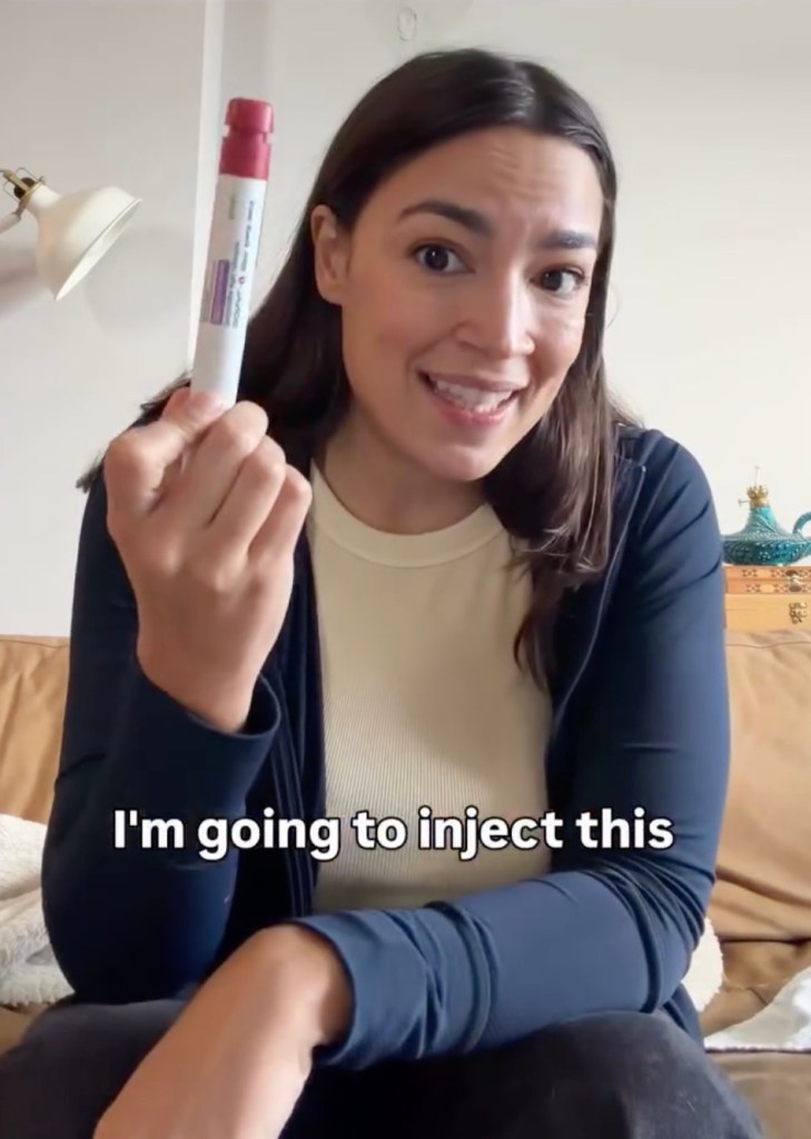 Alexandria Ocasio-Cortez holding up an injection pen for egg freezing.
