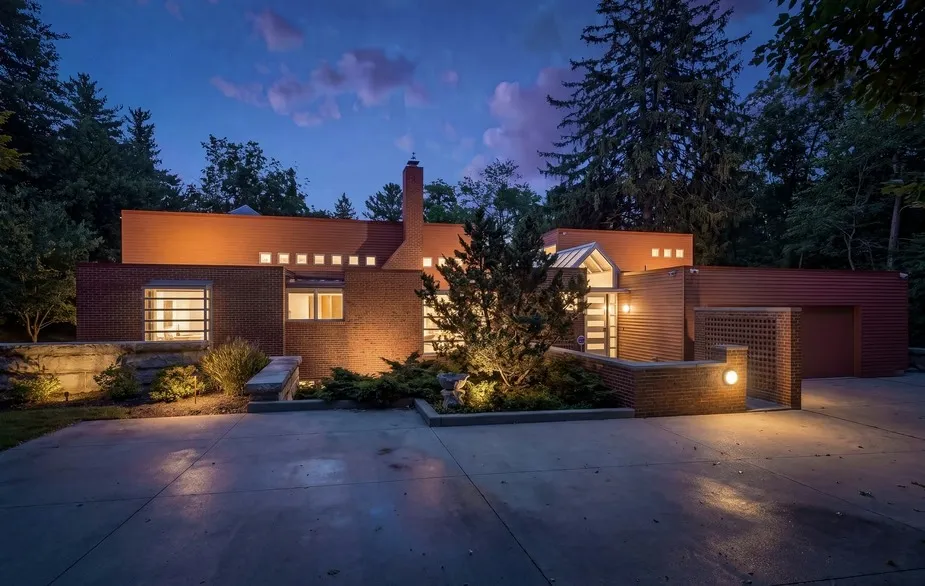 An upside-down house by architect Kenneth Neumann, illuminated at dusk.