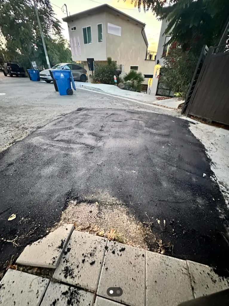 A poorly filled pothole in a street.