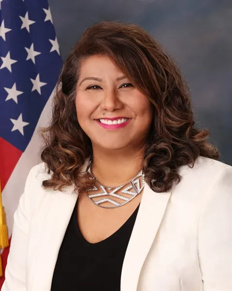 Headshot of Mayor Alma Hernandez smiling in front of an American flag.