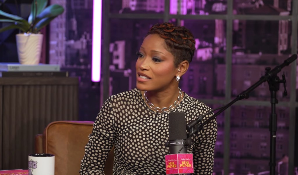 Keke Palmer speaking into a microphone on her podcast.