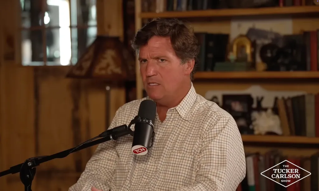 Tucker Carlson speaking into a microphone.