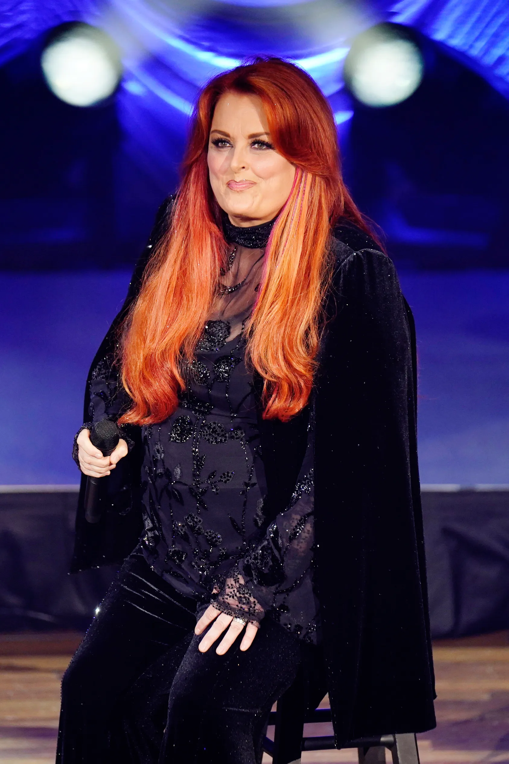 Wynonna Judd performing on stage.