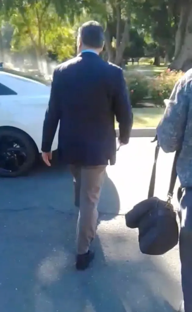 Xavier Becerra walking away from a press conference.