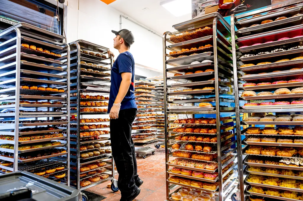 Yan Nihrutsa checks donuts shortly before the grand opening of Randy’s Donuts.