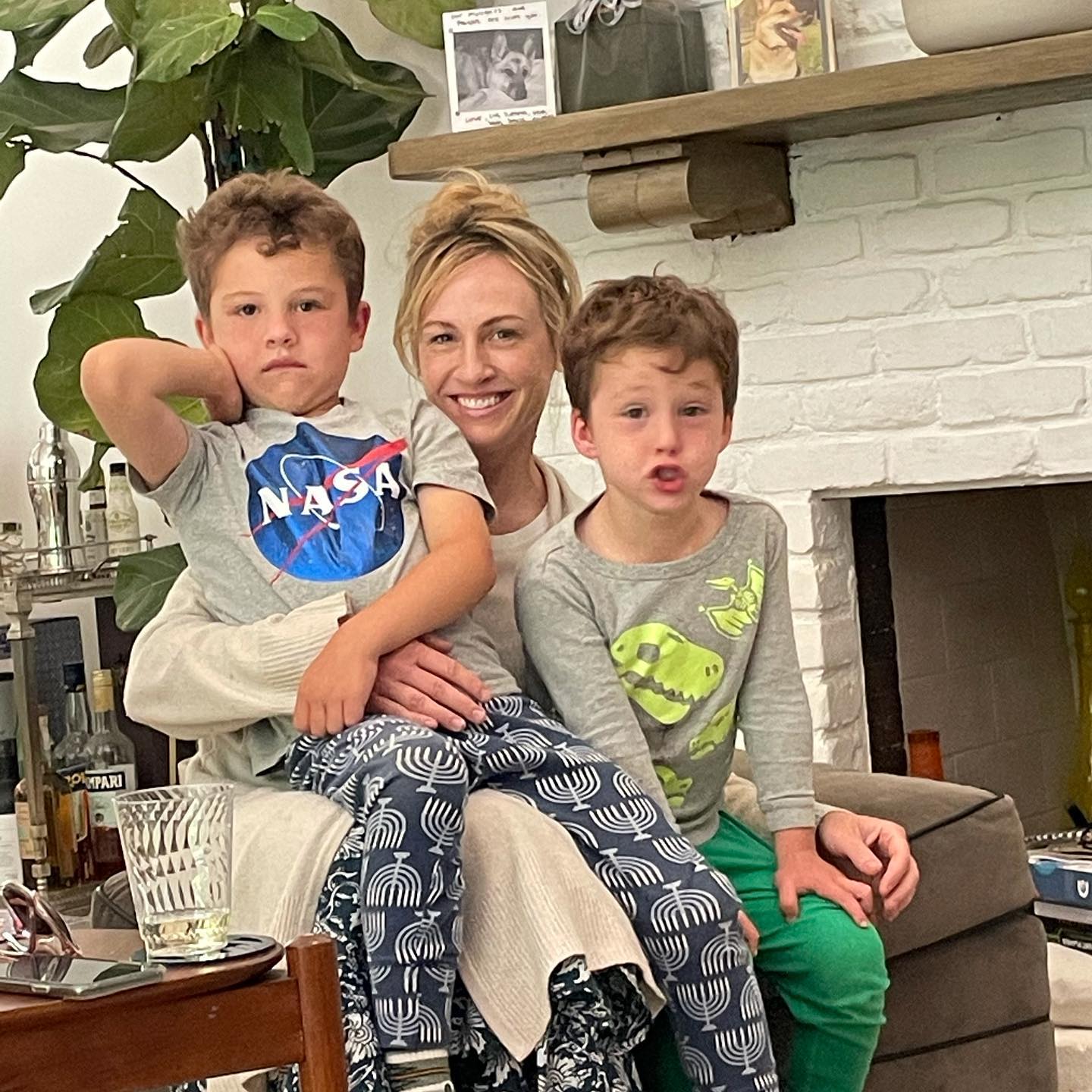 Woman posing with her two children indoors.
