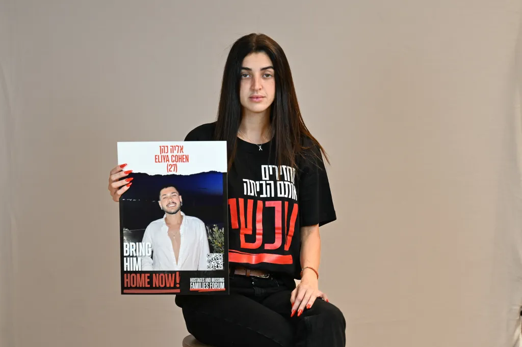 Ziv Abud holds a sign with a photo of Eliya Cohen and the text 
