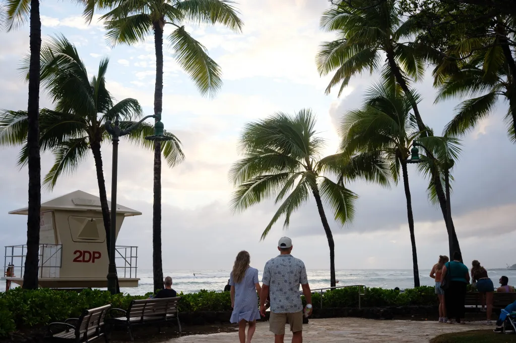 People walk along Waikiki Beach at sunset after Tropical Storm Lala passed, leaving behind flooding and power outages in Honolulu, Hawaii.