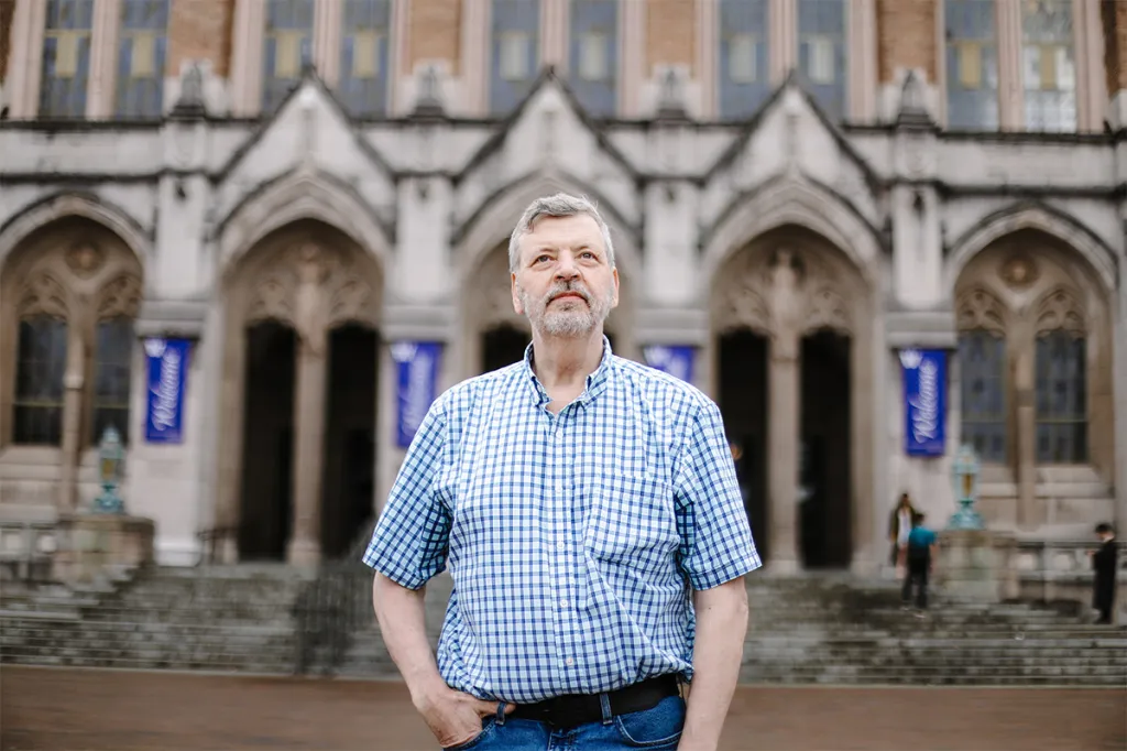 University of Washington professor Stuart Reges stands in front of a campus building.