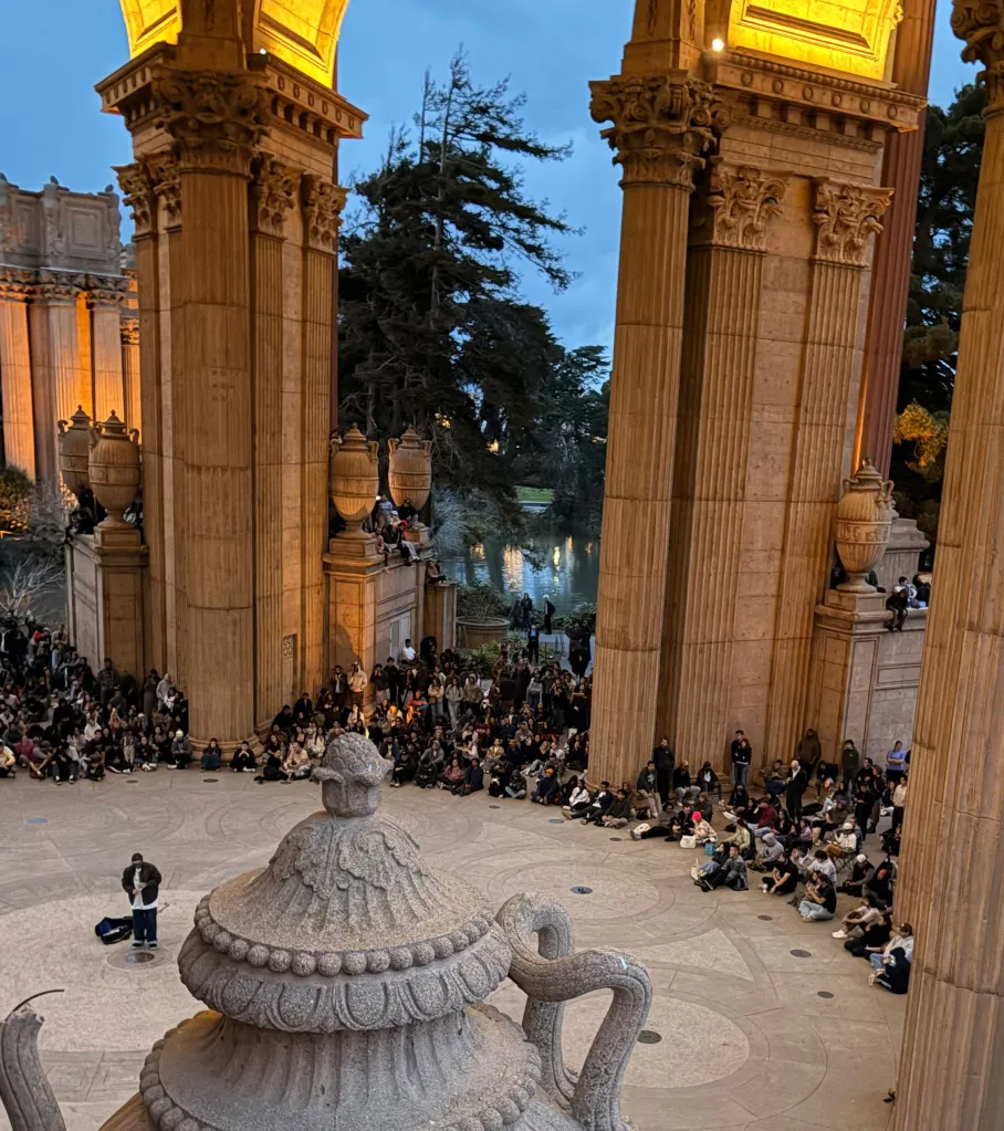 Nathaniel Young performing saxophone for a crowd at the Palace of Fine Arts.