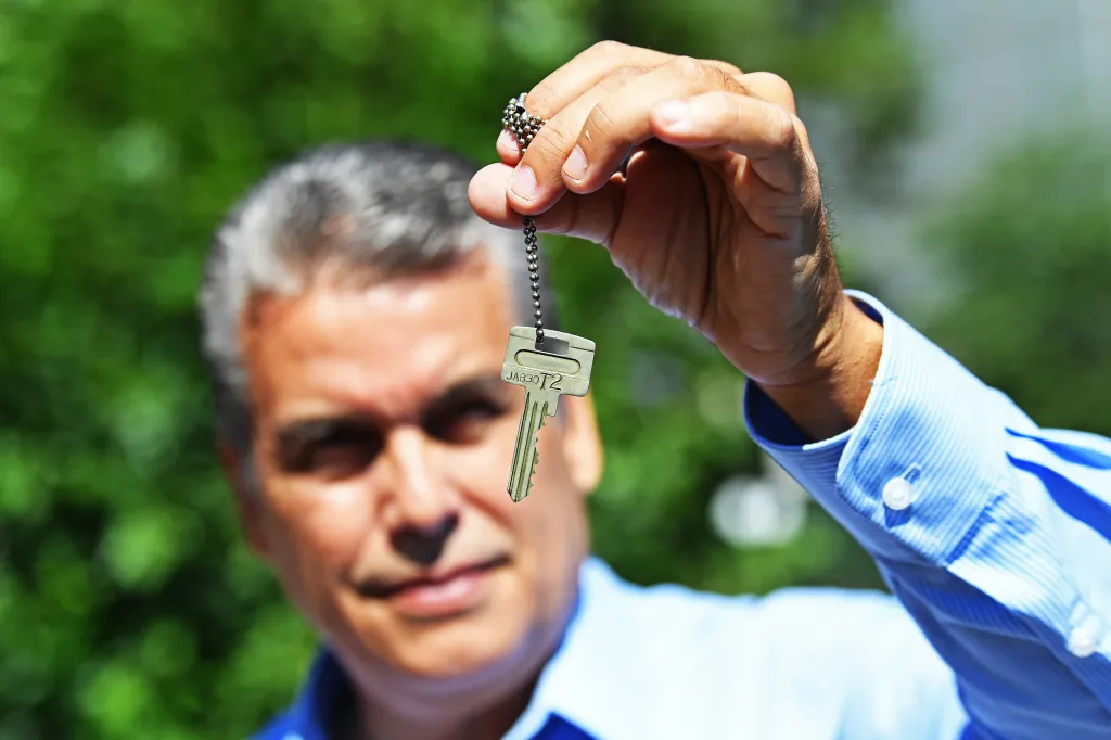 A man holds up a key on a chain, identified as the master key used by William Rodriguez to save lives during 9/11.
