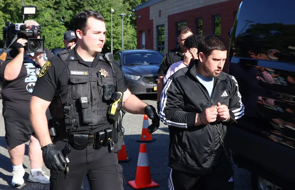 Sage Arias-Brown in handcuffs, escorted by a sheriff's deputy.