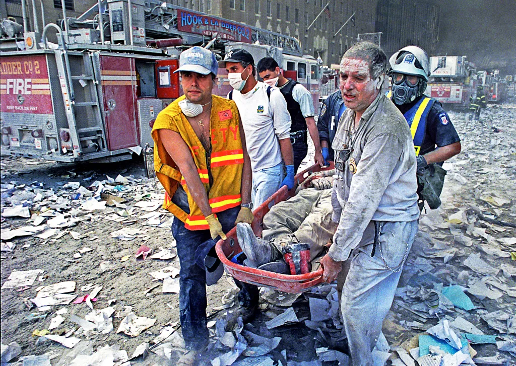William Rodriguez, wearing an FDNY reflective safety vest, helps to find survivors amidst the rubble and destruction.