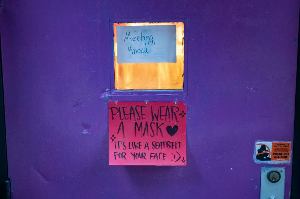 Mask sign on the front door of the Last Ditch Lesbian Bar.
