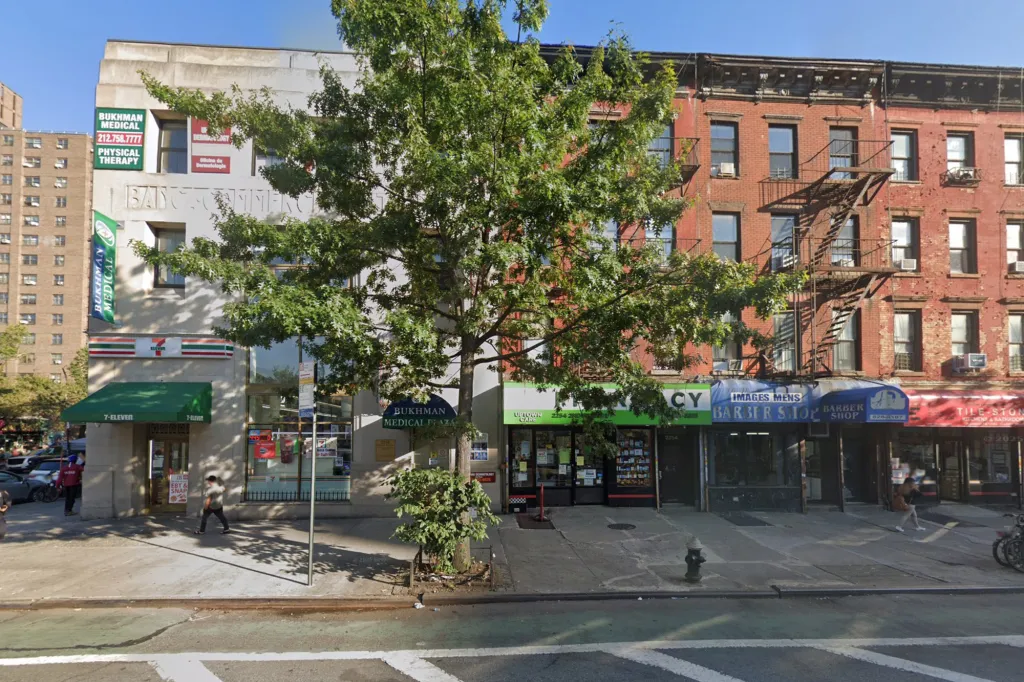 Google Street View of 2250 2nd Avenue in New York City, showing commercial establishments, including a 7-Eleven, a pharmacy, and a barber shop, beneath residential buildings.