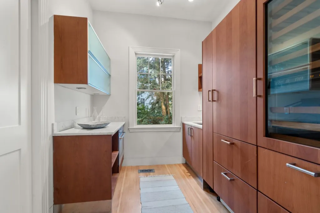The kitchen in Julia Child's former home, with light wooden cabinets and white countertops.
