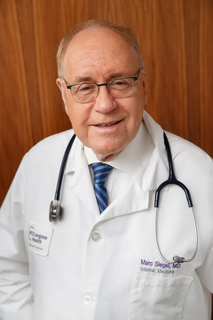 Dr. Marc Siegel, a FOX contributor, smiles in a white lab coat with a stethoscope around his neck.