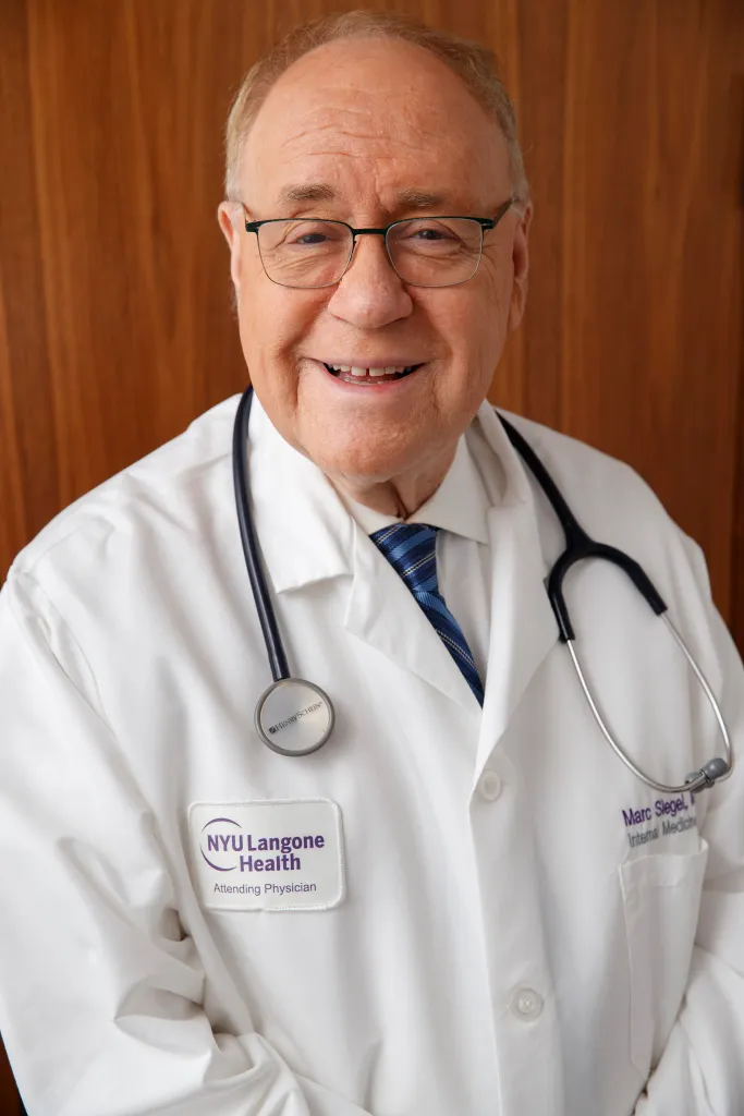 Dr. Marc Siegel, a FOX contributor, smiles in a white lab coat with a stethoscope around his neck.