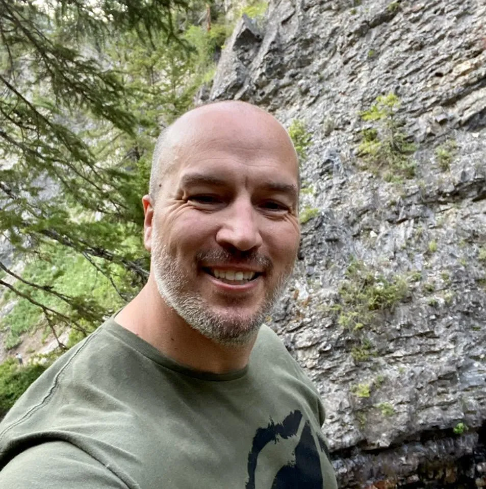 Brady Harmon, father of the slain children, smiling outdoors.