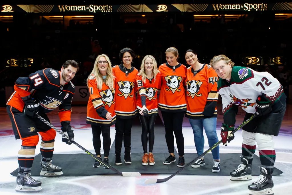 Adam Henrique, Linda Cohn, Julie Uhrman, Jillian Samueli-Reddin, Misty May-Treanor, Lauren Chamberlain, and Travis Boyd pose for a ceremonial puck drop on Women in Sports Night.
