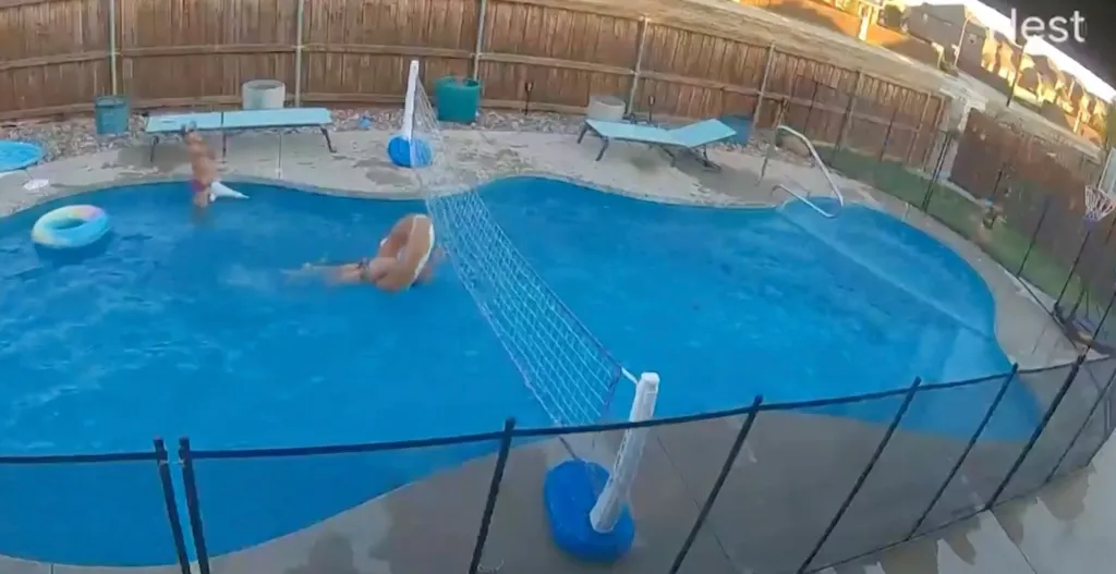 Two people playing volleyball in a pool.