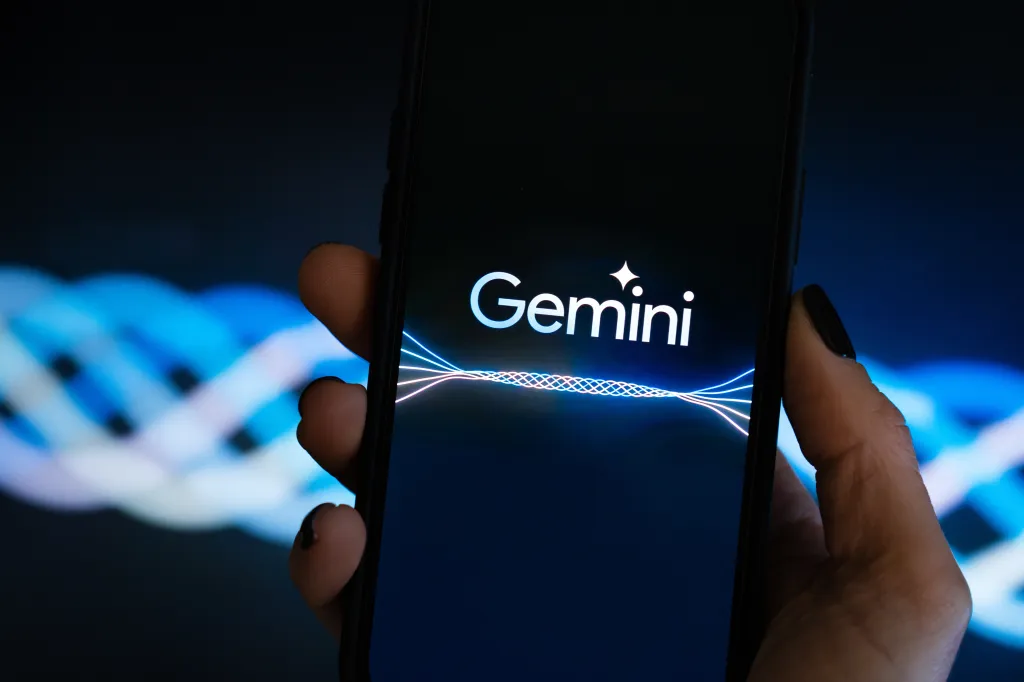 Hand holding a smartphone displaying the Google Gemini AI logo.