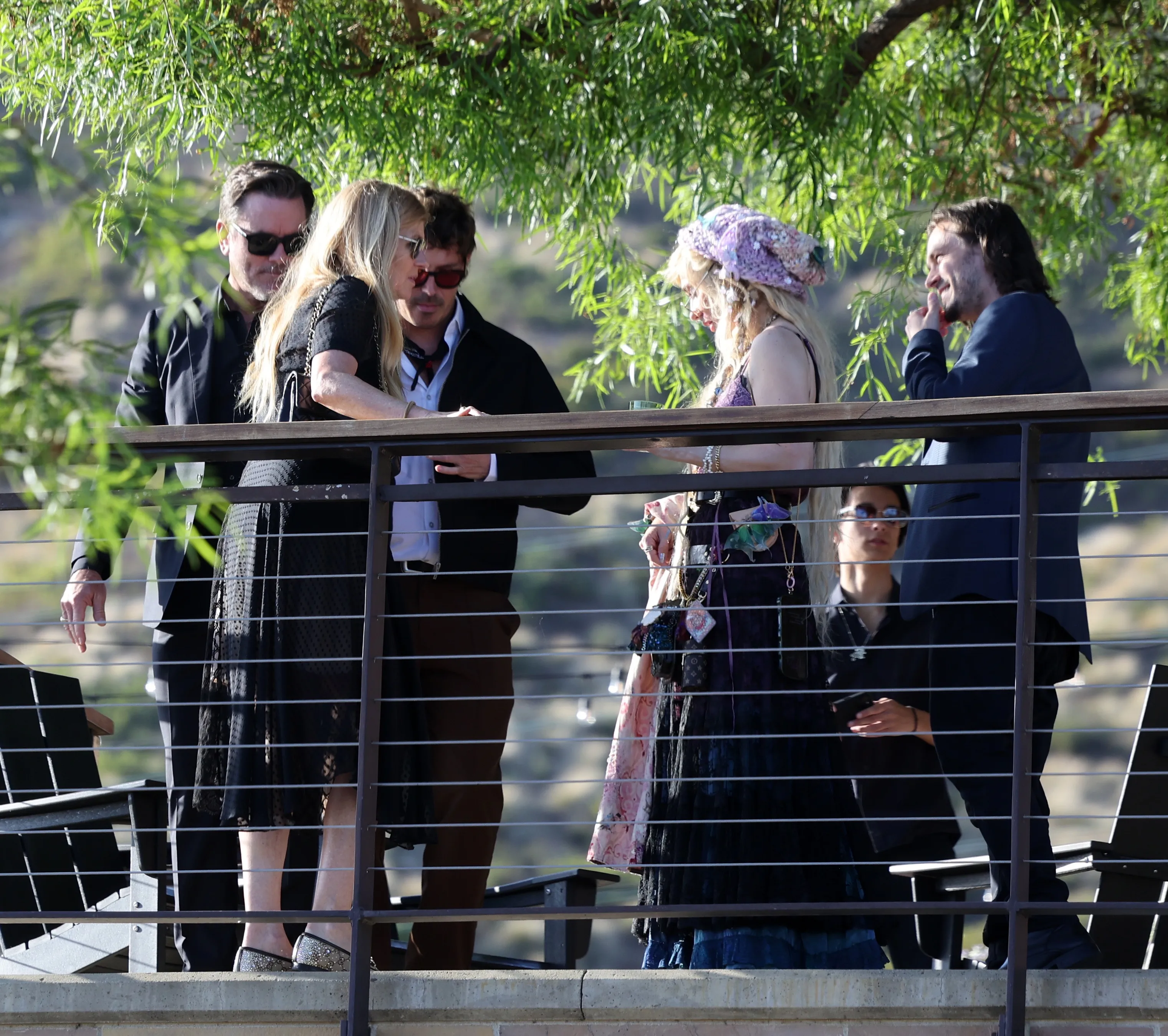 Connie Britton, Sam Palladio, and Jonathan Jackson are gathered together outdoors on a balcony.