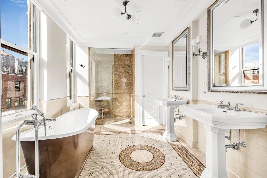 The two-floor, roughly 5,700-square-foot home features more than 40 oversized windows, two grand foyers, a circular limestone staircase, and a private roof deck with sweeping skyline views.
