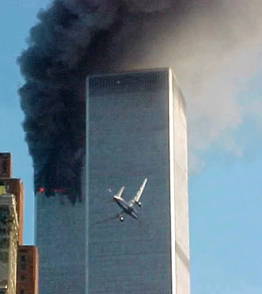 United Airlines Flight 175 approaches the south tower of the World Trade Center as smoke billows from the north tower.