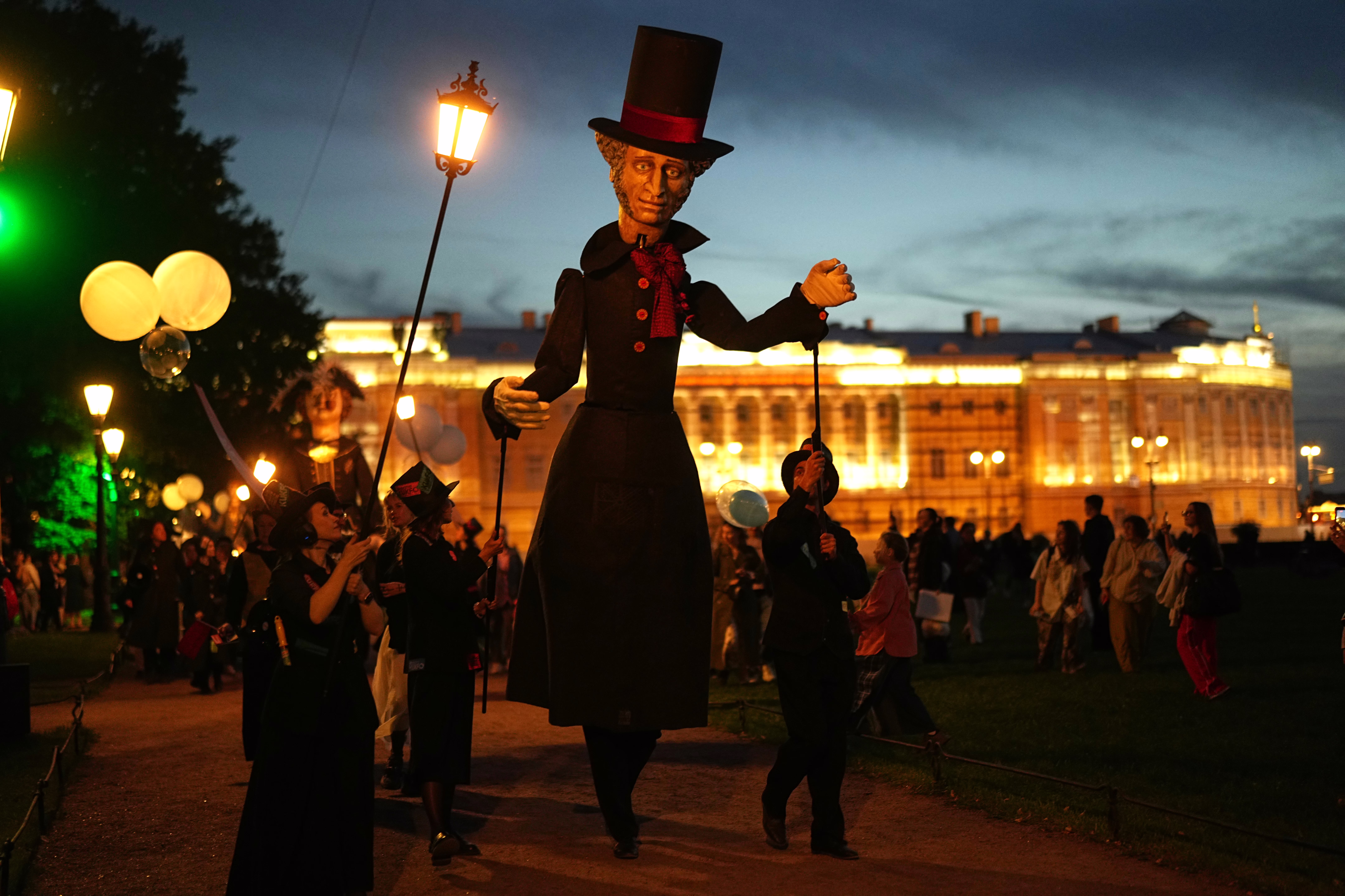 Performers walk with a giant puppet figure depicting the Russian poet Alexander Pushkin.