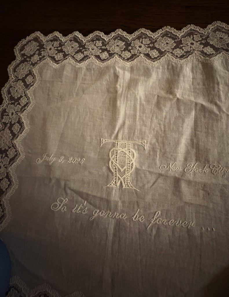 White lace-edged cloth embroidered with a 