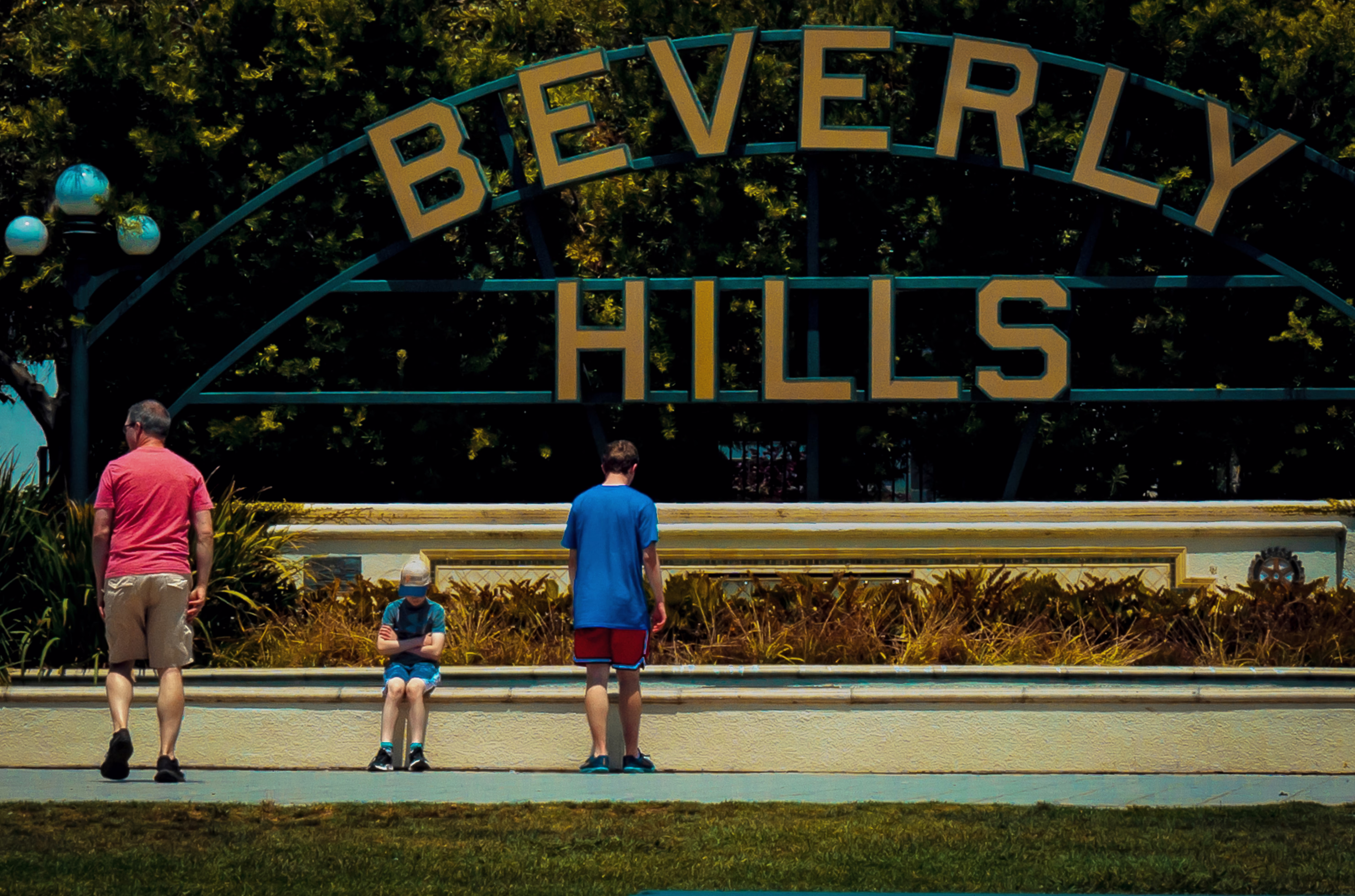 photo of several people in front of large 'BEVERLY HILLS' sign
