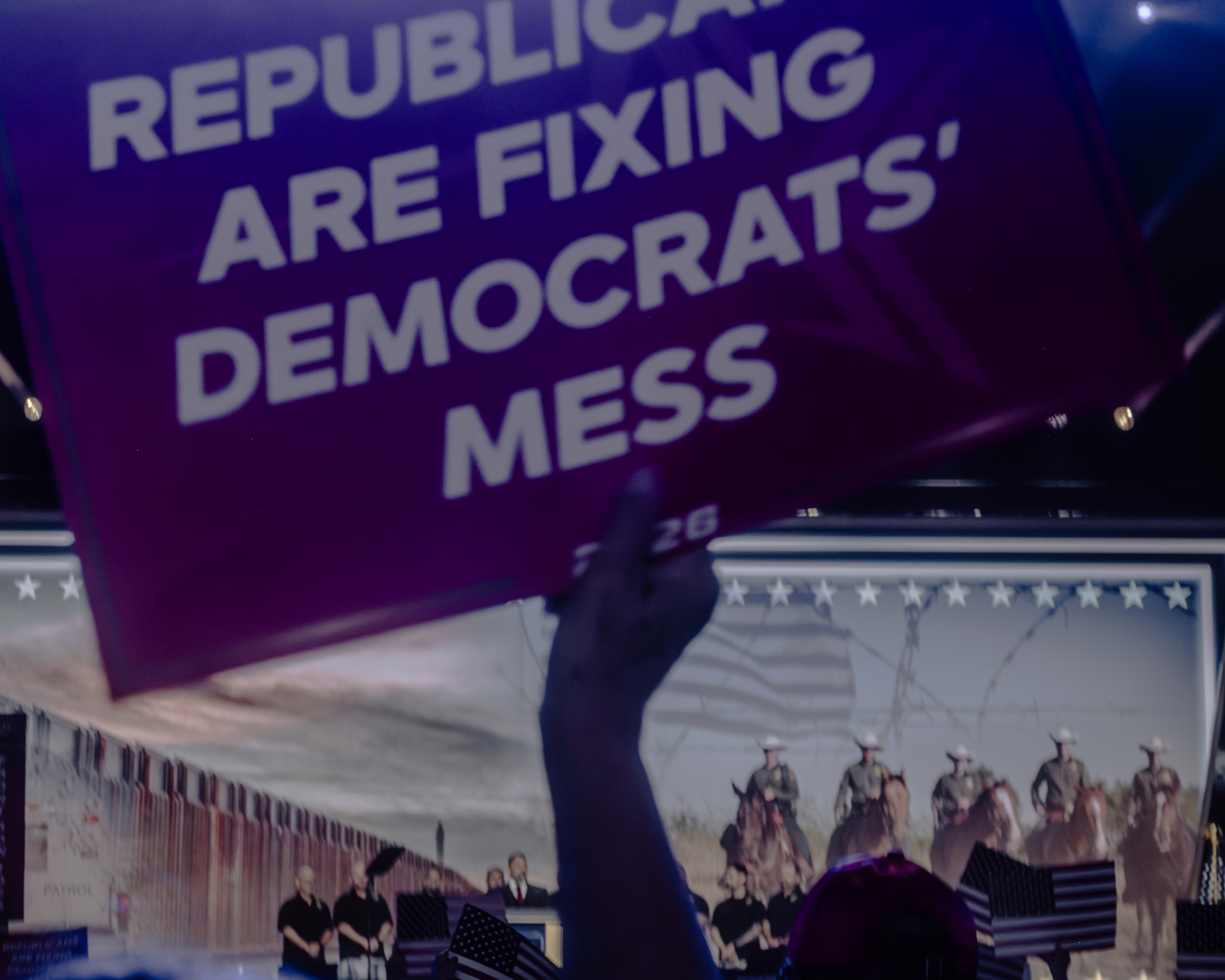 a person holds a sign in front of a stage