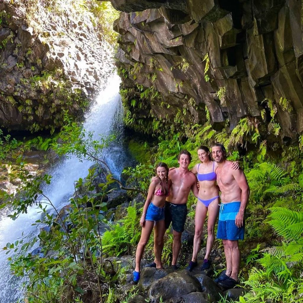 Aaron Rodgers, Shailene Woodley, Miles Teller, and Keleigh Teller posing in front of a waterfall in Hawaii.