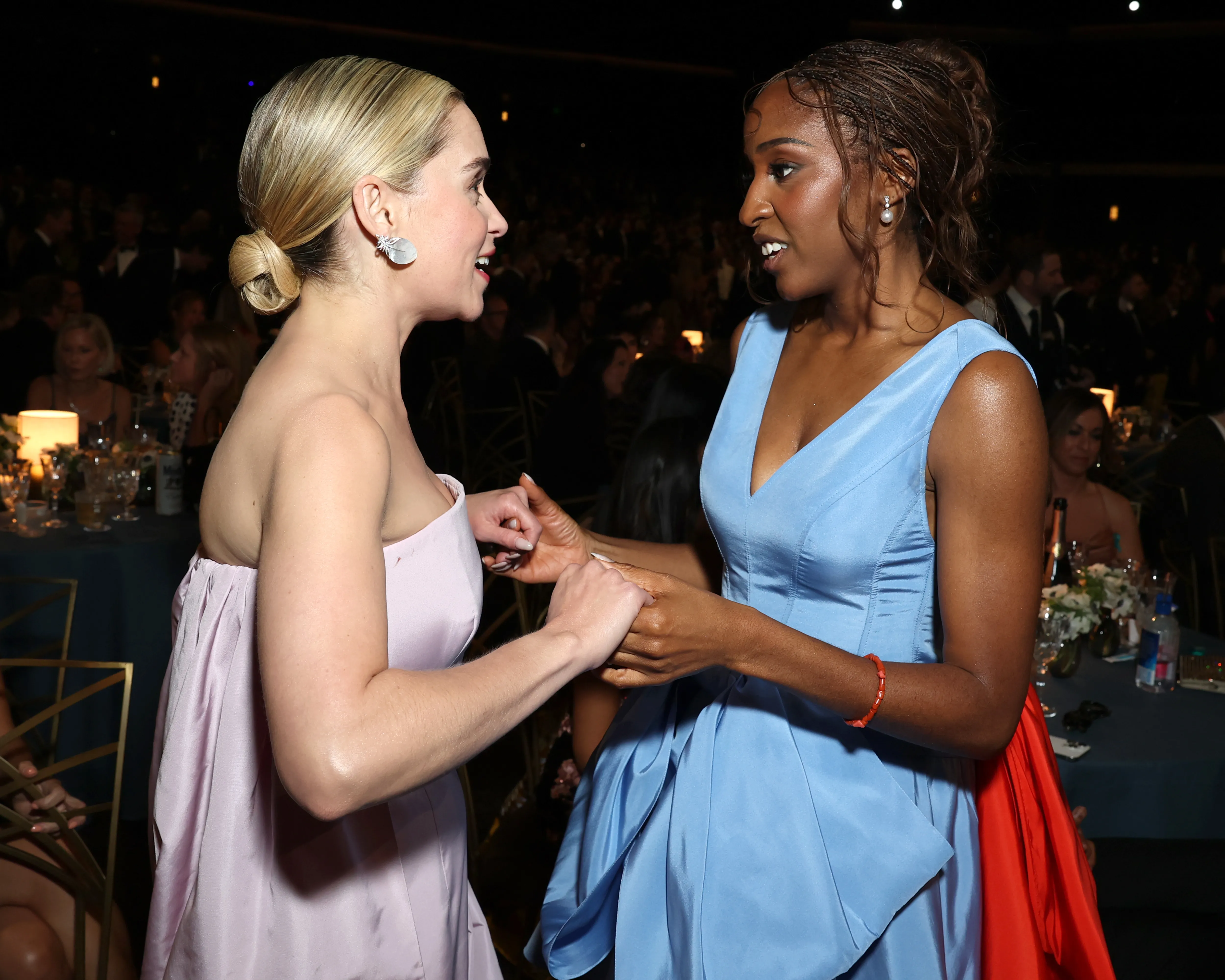 Emilia Clarke in a light pink dress and Ayo Edebiri in a light blue dress with an orange ruffle at the 78th Primetime Emmy Awards.