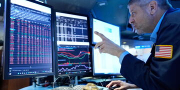 Stocks slip after the Fed hikes interest rates and hints more increases may be on the way