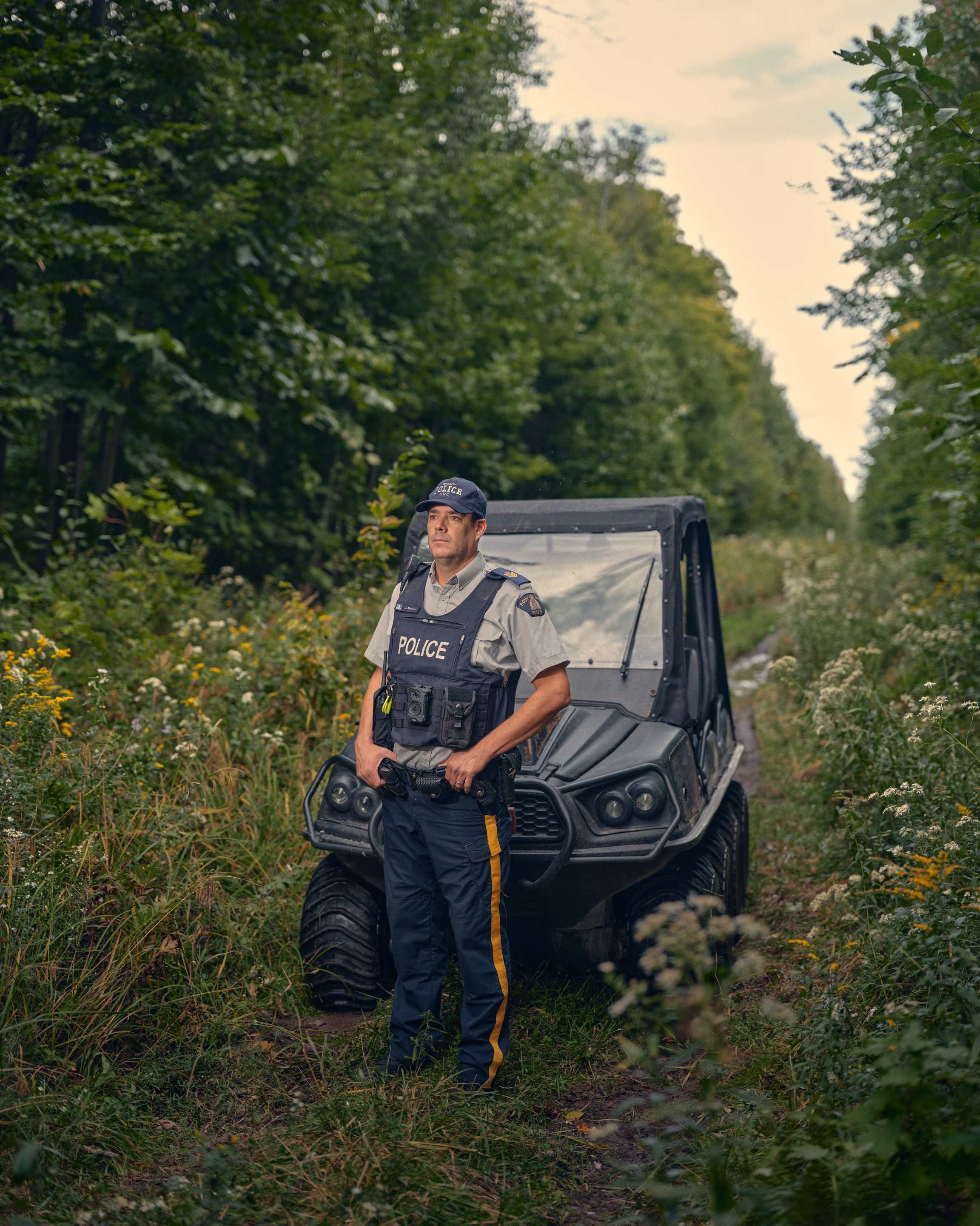 a police officer stands in the woods