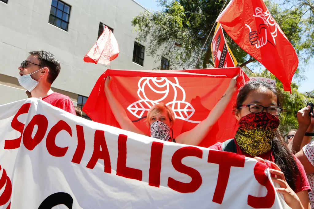 Democratic Socialists of America counter-protesters holding a large white banner with 