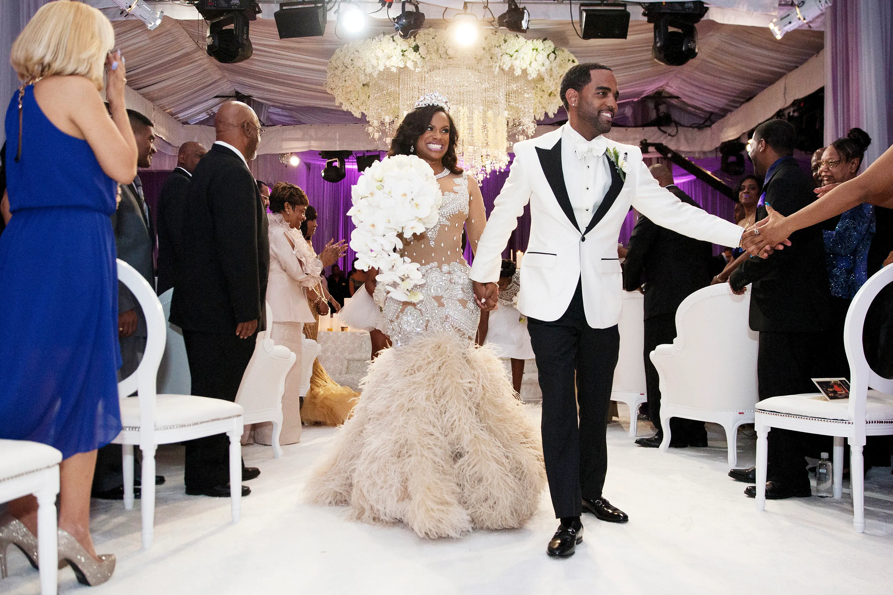 Kandi Burruss and Todd Tucker holding hands and walking down the aisle at their wedding.