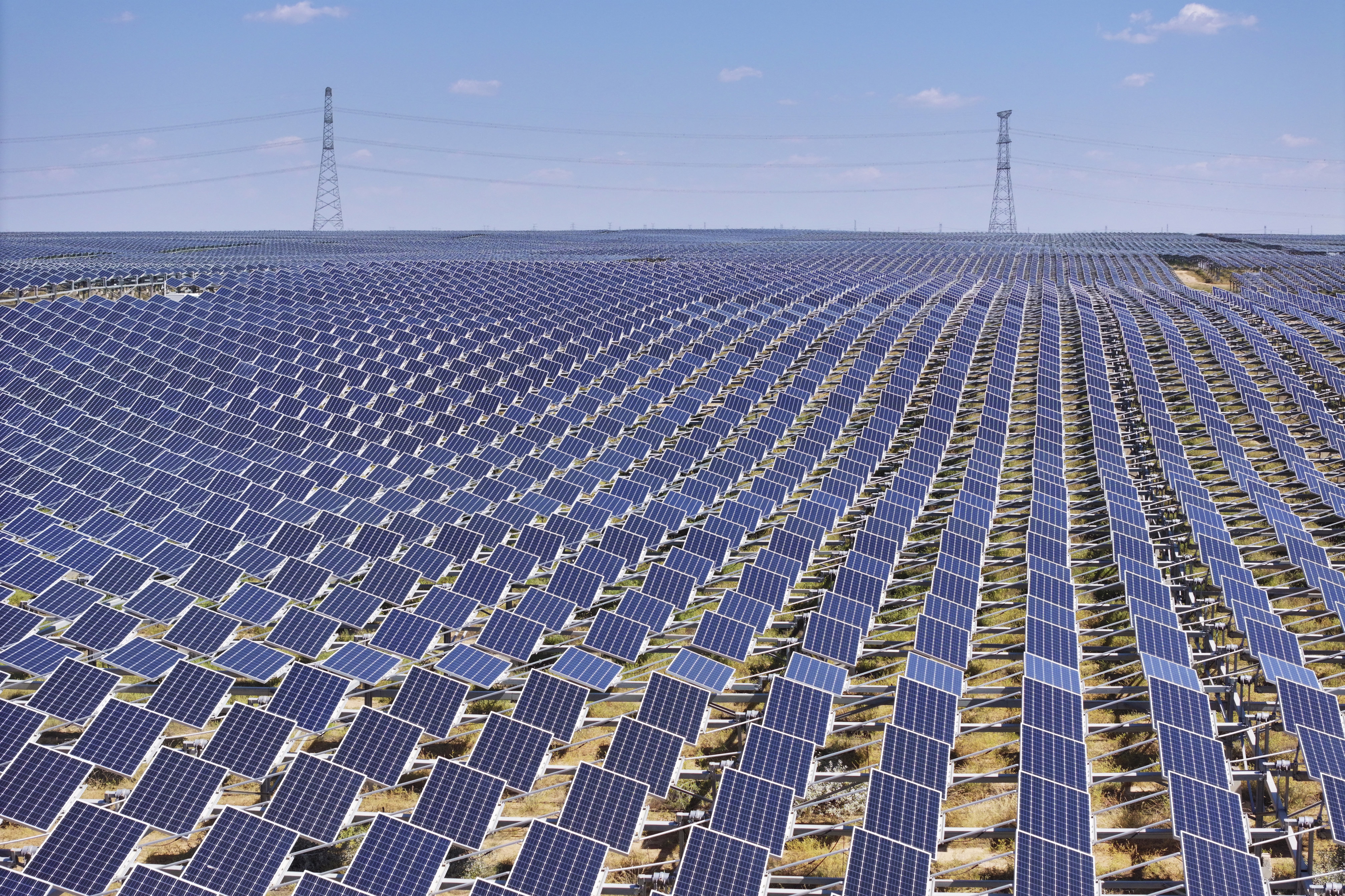 Thousands of solar panels cover a field, visible to the horizon.