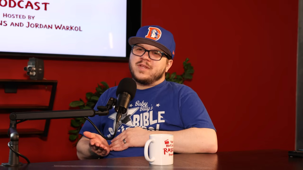 Justin Cooper speaking into a microphone on a podcast.