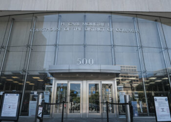 She was arrested and faced charges for months, but her twin was the suspect, suit says