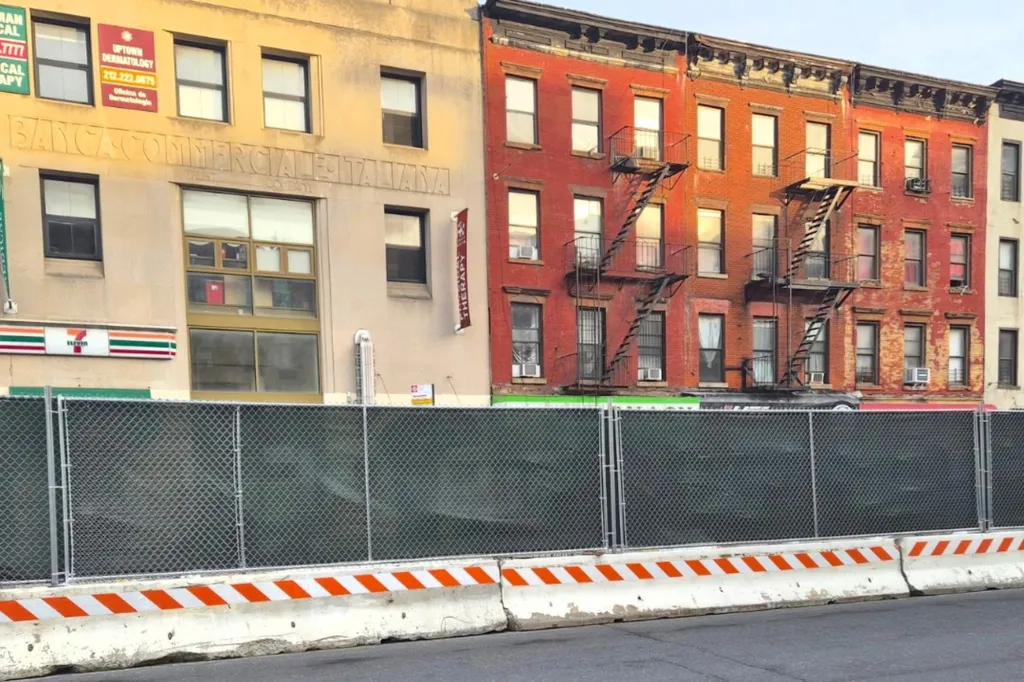 A chain-link construction fence blocks access to businesses on 2nd Avenue, including a 7-Eleven, in New York.