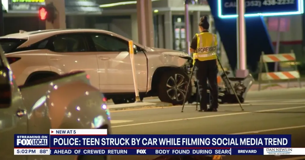Police investigate the scene of a the two-car crash that seriously injured the teen getting a haircut in the middle of the road.