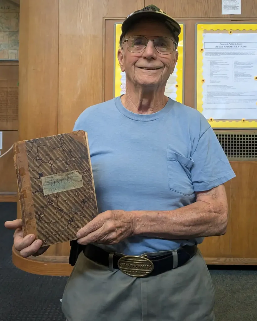 John Hanson holding a worn, old copy of 